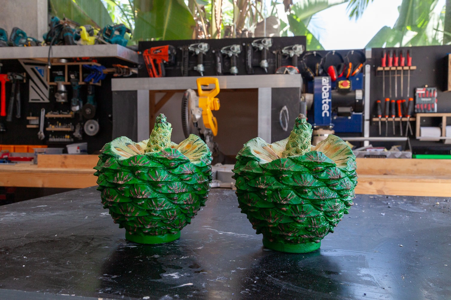Two open bunya cone forms side by side on the workshop bench