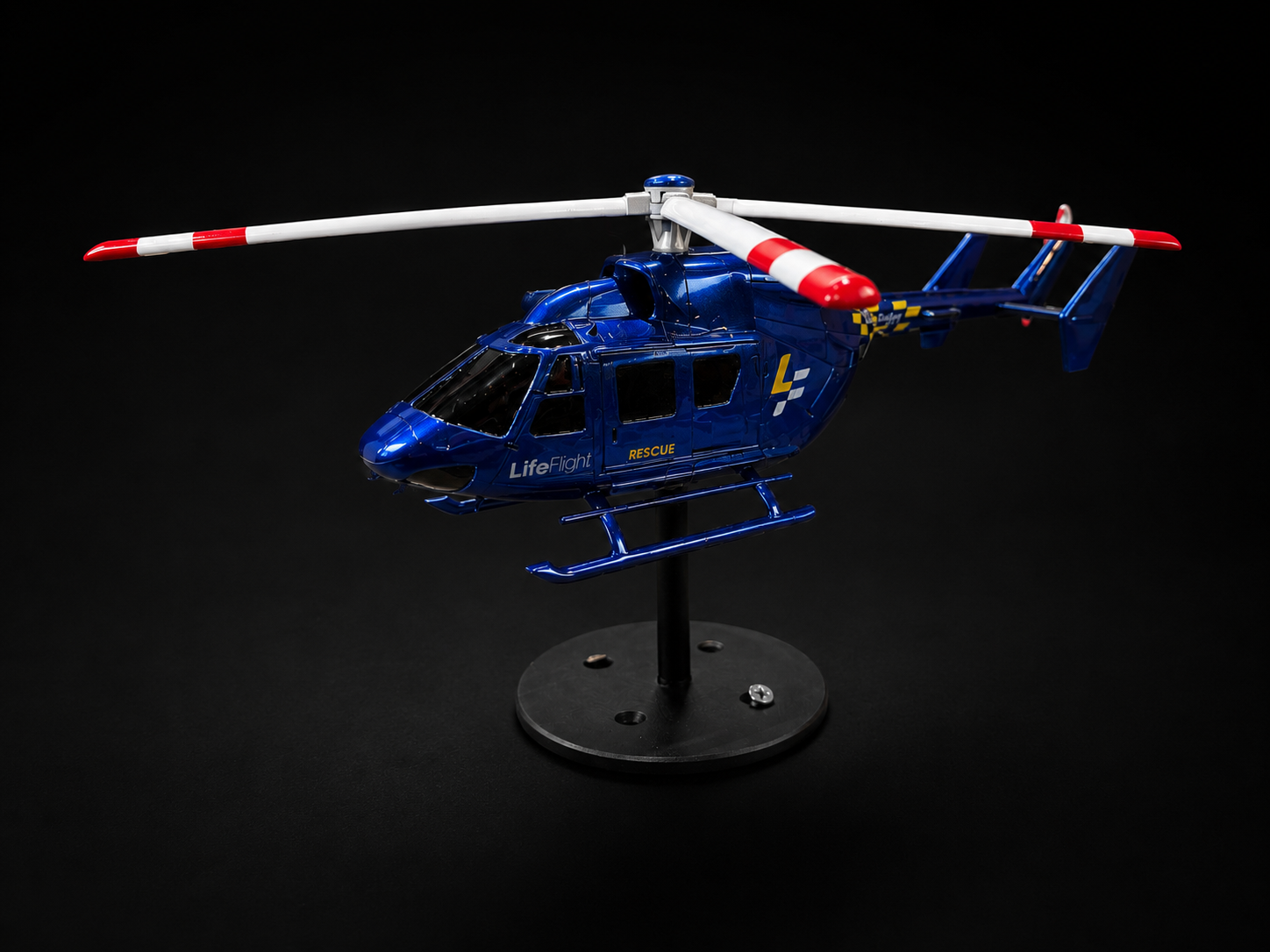 Blue rescue helicopter scale model mounted on a black display stand