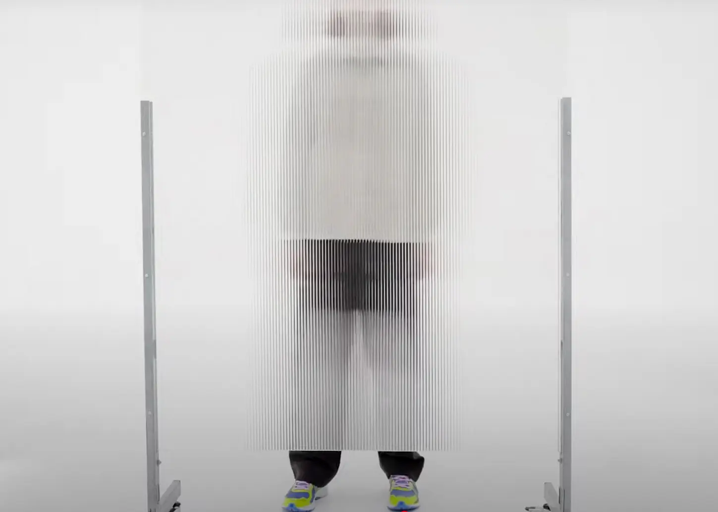 A person seen through the reeded acrylic retail installation for Up There x New Balance